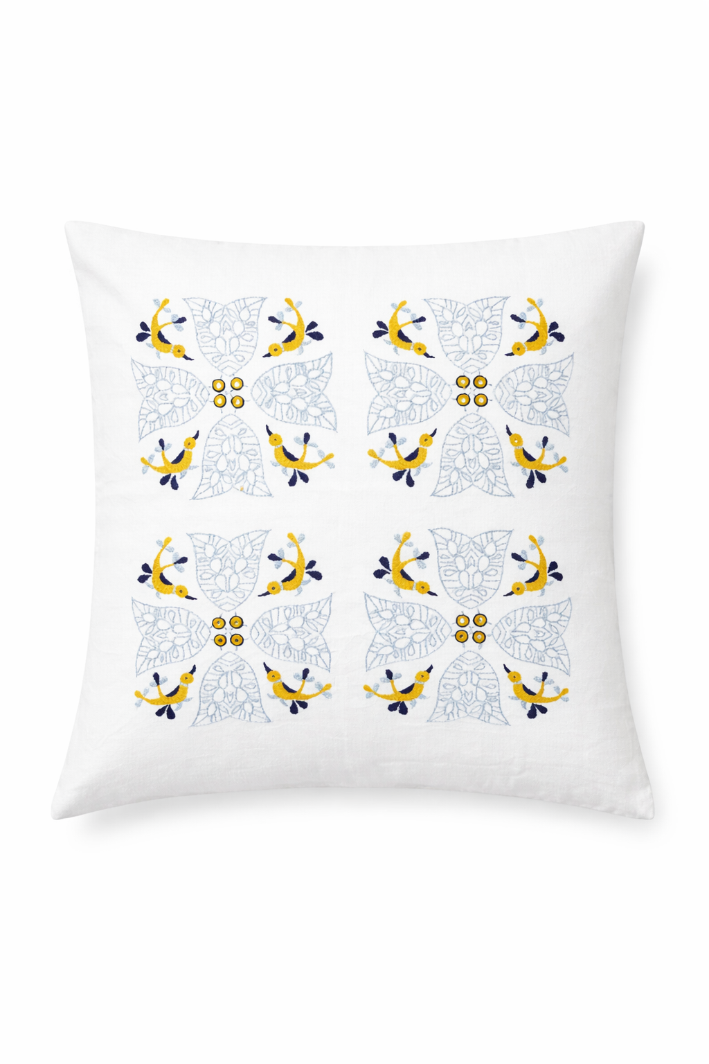 White cushion cover featuring a symmetrical embroidered pattern of four floral medallions. Each motif includes delicate pale blue leaves and small yellow birds arranged around the centre, with navy accents and tiny yellow circular details. The repeating folk-inspired design creates a light, decorative look against the crisp white fabric.